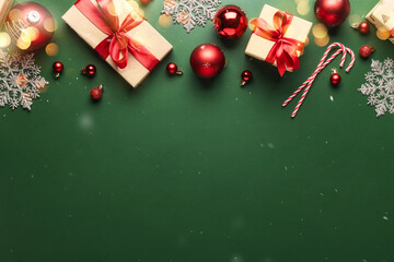 Christmas or New Year background. Paper gift boxes, with red ribbon and tie bow, Christmas balls on green background with copy space top view