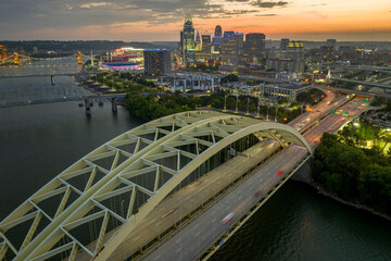 Aerial view of downtown district highway traffic in Cincinnati city, Ohio at night. Brightly illuminated high skyscraper buildings in modern American midtown