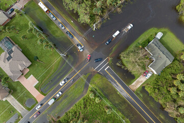 Aerial view of flooded street after hurricane rainfall with driving cars in Florida residential...