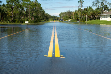 Flooded Florida road in suburban residential area. Driving hazard. Consequences of hurricane...