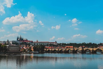 Scenic outdoor scene of a sparkling river with Charles bridge in the background in Prague
