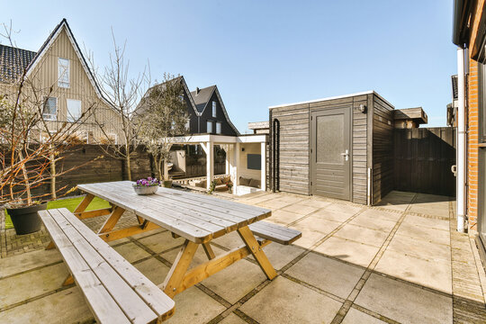 Wooden picnic table in patio outside houses