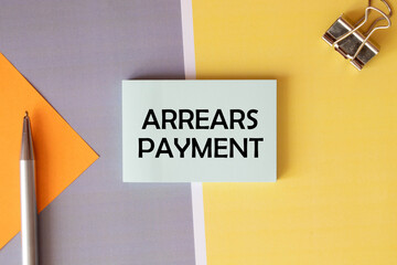 Arrears Payment write on a book isolated on Wooden Table.