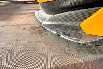 Broken carbon fiber bumper of an orange sports car close-up. Loading the car onto a tow truck and...