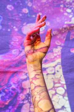 Painted hand signaling peace in cosmic realm