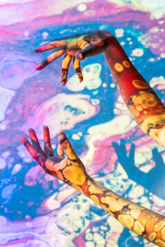 Painted hands gesturing in cosmic harmony