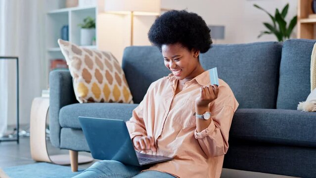 Excited woman shopping online for bargains and sales with laptop and credit card at home. Cheerful consumer and happy shopper saving on awesome deals and discount bookings while spending money