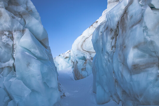 Ice formations on snowcapped mountain against clear sky