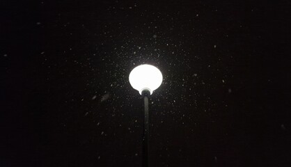 street lamp glowing at snowy night