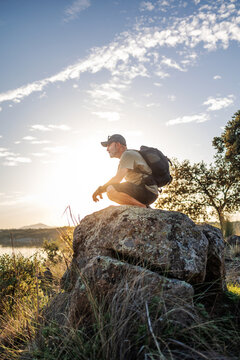 Man resting on boulder at sunset in Pantano de Layos
