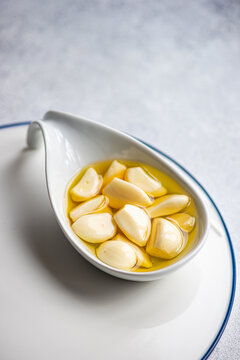 Baked organic garlic in oil on spoon