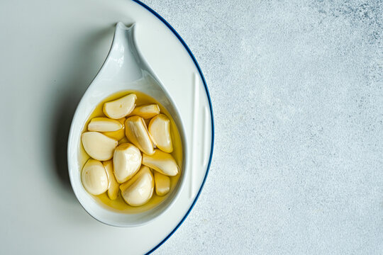 Baked organic garlic in oil on spoon