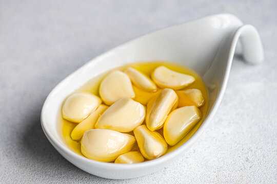 Baked organic garlic in oil on spoon