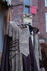 Array of medieval clothing hung up on a wall-mounted coat rack