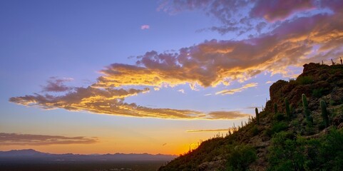 Sunset at Gates Pass in Tucson, Arizona illuminated by a golden orange evening sky