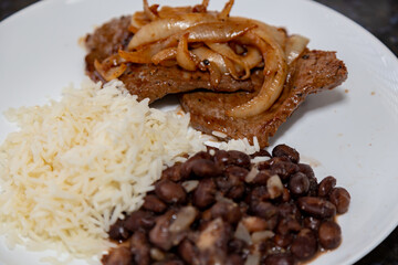 The most traditional Brazilian lunch dish, black beans, rice and onion steak