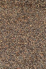 Crop of many dry green lentil grains on flat surface as background