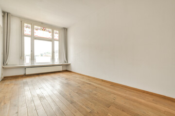 an empty room with wood flooring and white walls in the background is a large window that looks out onto the street
