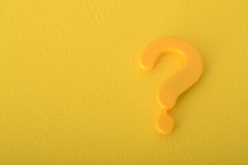 The question mark symbol isolated on a yellow background acts as a beacon, inviting people to make...