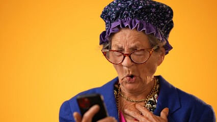 Closeup of toothless funny old crazy grandmother wearing glasses isolated on yellow background...