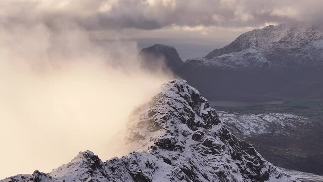 Winter Wonderland Unveiled: Aerial Drone View Soaring to Lofoten's Snow-Covered Mountains in Norway