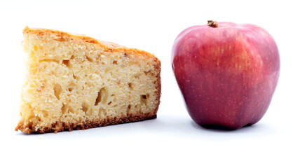 closeup of a slice of homemade apple pie with a red apple next to it on a white background