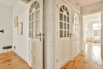 a room with wood flooring and white brick wall behind the door is a green chair that sits in front...