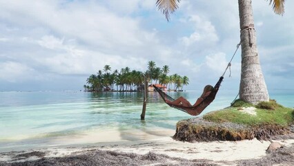 Woman lying on an hammock in a paradise island