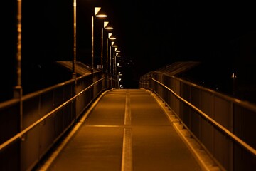 Empty illuminated walkway in the night