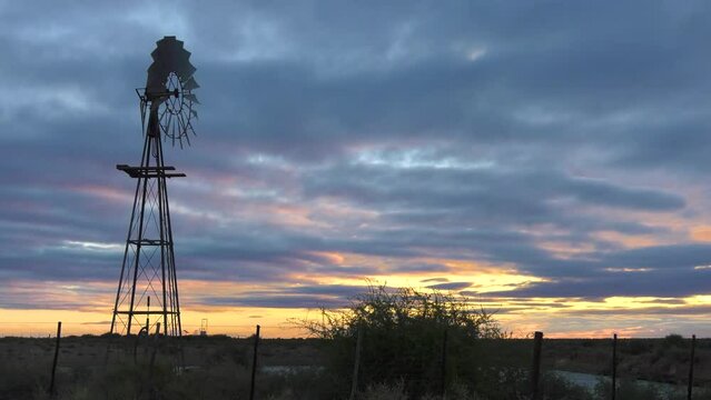 vintage windmill providing energy to a water pump for the farm, outback in the dry land