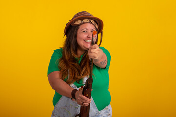 Fat woman wearing a cangaceiro hat and holding a shotgun in reference to the Festa Junina in Brazil