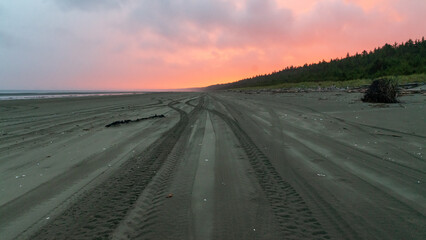 Sun rising in the distance on North beach, Haida Gwaii, British Columbia, Canada