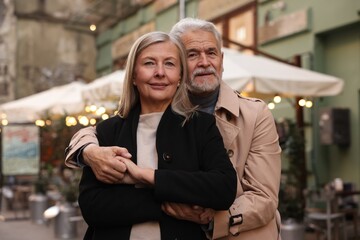 Portrait of affectionate senior couple on city street