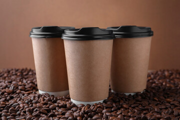 Coffee to go. Paper cups on roasted beans, closeup