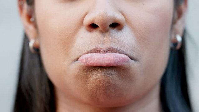 Closeup of sad mouth and pouting lips in sulking, disappointed facial expression while showing sadness. Face with detail of an unhappy woman trying not to cry while remembering past memory or mistake