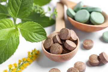 Different pills and herbs on white background, closeup. Dietary supplements