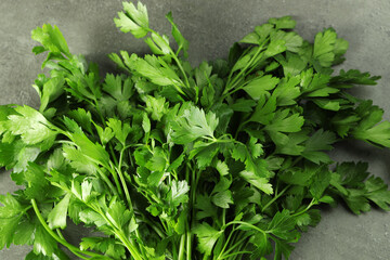 Bunch of fresh green parsley leaves on grey table, top view