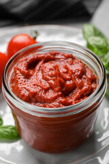Jar of tasty tomato paste on table, closeup