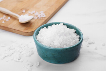 Bowl with sea salt on white marble table, closeup