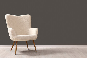 Stylish armchair near grey wall indoors, space for text