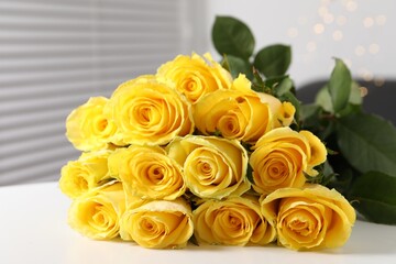 Beautiful bouquet of yellow roses on white table indoors, closeup