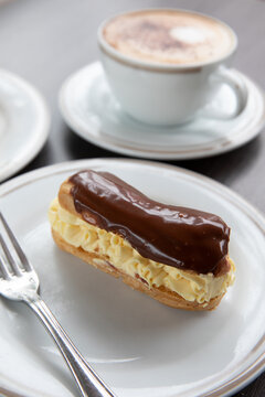 Chocolate eclair and cup of cappuccino