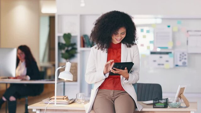 HR manager scrolling through resumés on her handheld tablet while standing in her office. An African female employer searching the internet or social media for employees