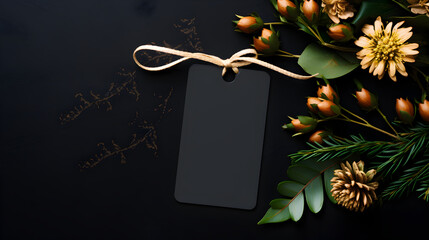 Holiday Christmas card background with gift tag and flora decoration on a black background from Flat lay, top view. 