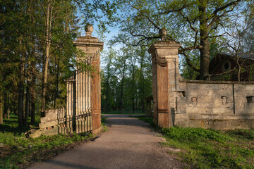 Fototapeta na wymiar View of the Menagerie (Zverinskiye) Gate - stone gate to the Eagle Grove, between the Menagerie and the Palace Park in Gatchina Park on a sunny summer day, Gatchina, Leningrad region, Russia