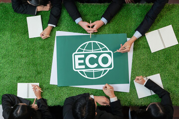 Top view panoramic ECO symbol on green grass table with business people planning for alternative energy utilization for greener sustainable Earth as corporate social responsibility. Quaint
