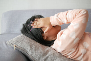 a upset child girl cover her face with hand 