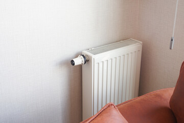 White radiator on grey white wall. apartment heating installation system, 