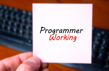 PROGRAMMER WORKING text, inscription in hand on the background of a computer keyboard. Programmer, developer, vacancy concept