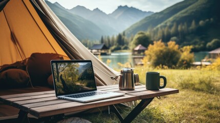 outdoor desktop business office beside camping tent on summer holiday.	